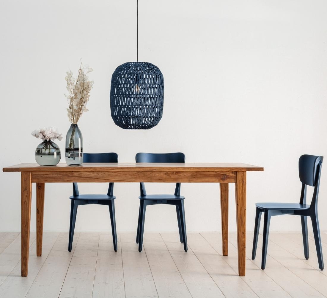 Seitenansicht des Tischs ARAVELLO, zeigt die Form und Verarbeitung aus Ulmenholz. ANOLO Stühle in der Farbe Ink.